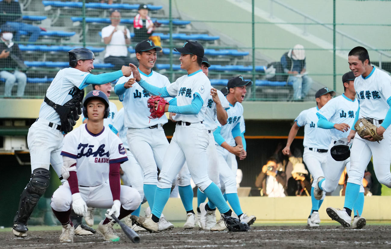 山梨学院対桐光学園　タイブレークの末、桐光学園に勝利しタッチを交わす針尾（中央）ら山梨学院ナイン（撮影・横山健太）