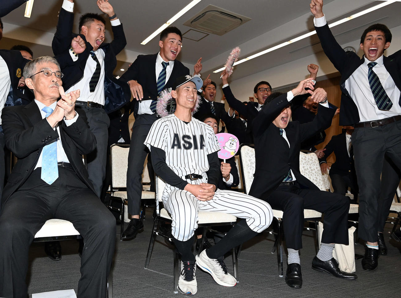 中日から1巡目の指名を受け、チームメートと笑顔を見せる亜大・草加（中央）（撮影・たえ見朱実）