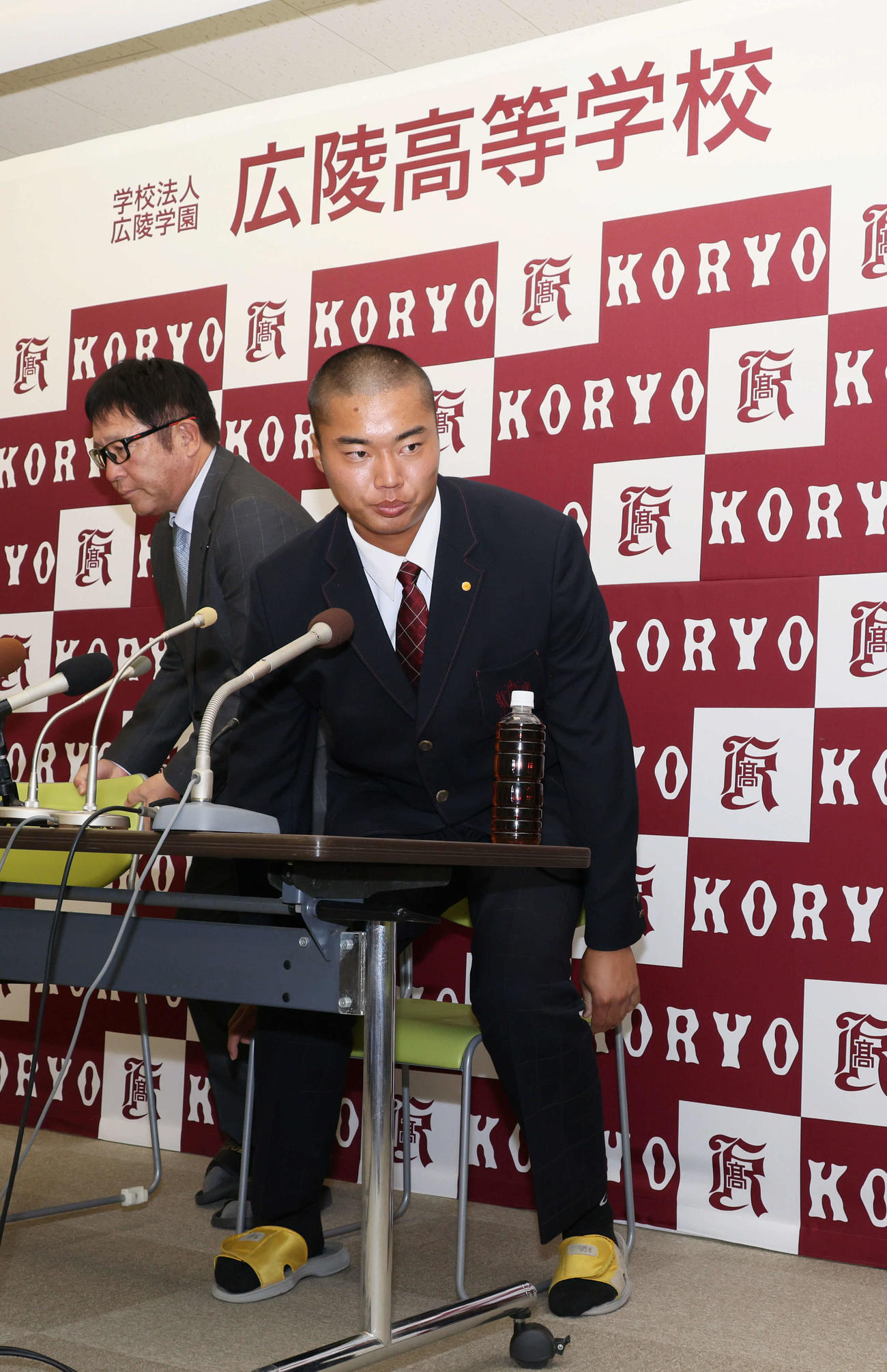 2023プロ野球ドラフト　4位までに選ばれず会見場を退席する広陵高校の真鍋。左は中井監督（撮影・加藤孝規）