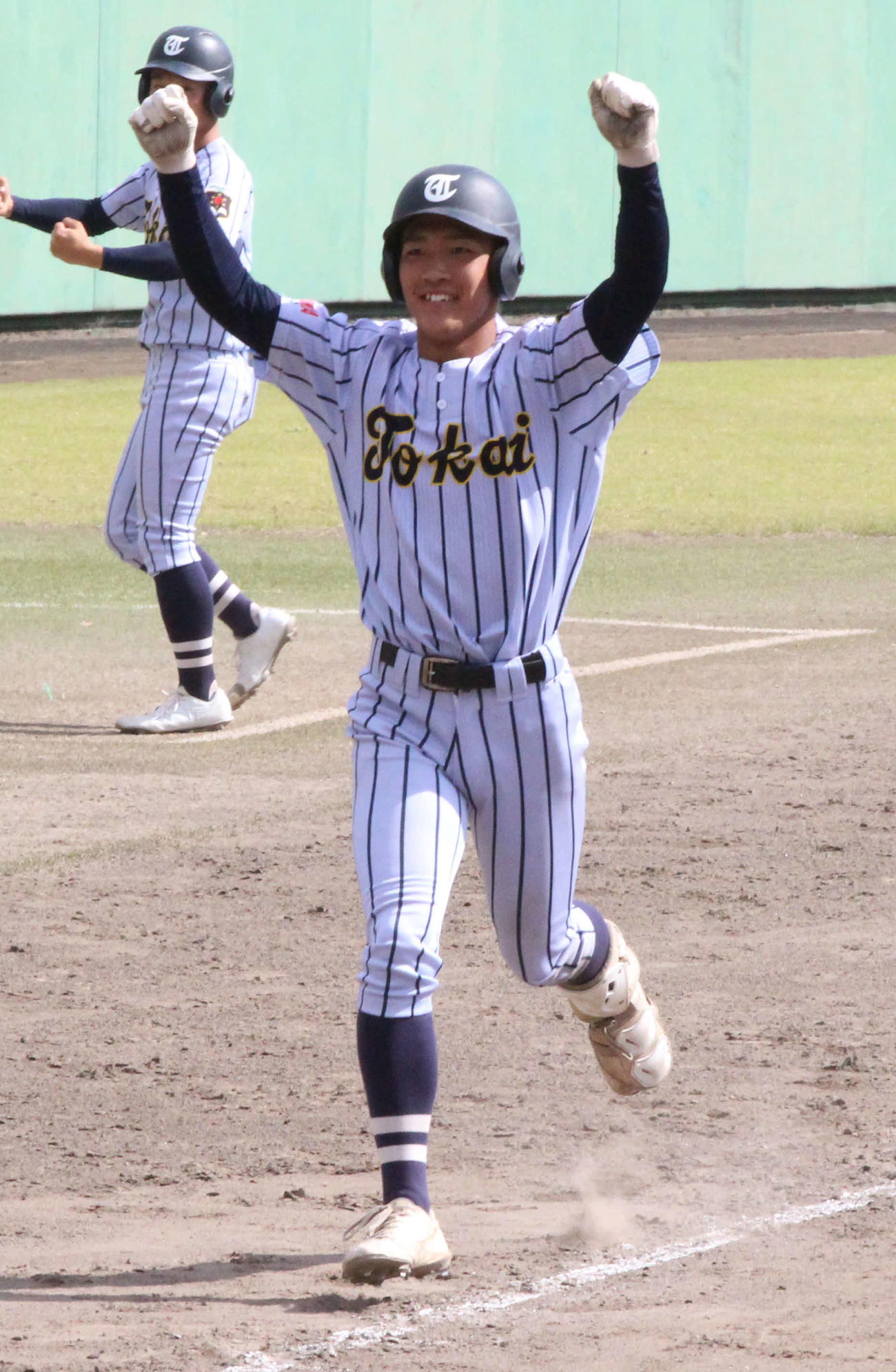 東海大福岡対九州学院　9回表東海大福岡2死一、二塁、左越え同点3ランを放ち、ガッツポーズで生還する唐崎（撮影・菊川光一）
