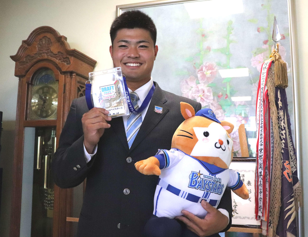 DB．スターマンのぬいぐるみとドラフトIDパス手に白い歯を見せる、DeNA育成3位京都翔英の小笠原