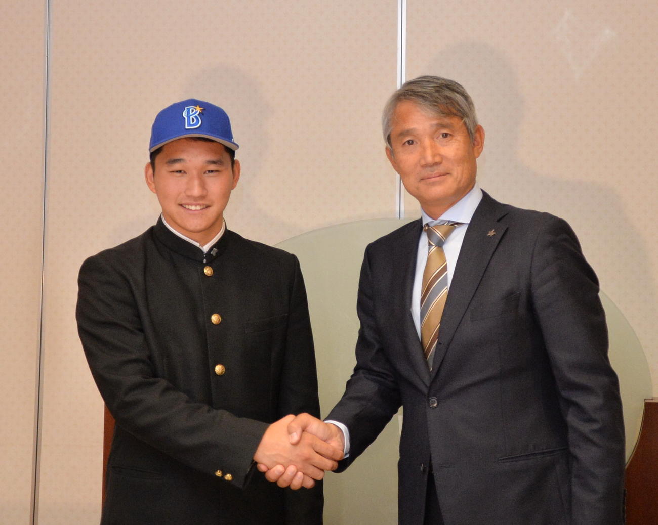 DeNAと仮契約を結んだ山形中央・武田（左）は、河野スカウトと握手を交わす（撮影・濱本神威）