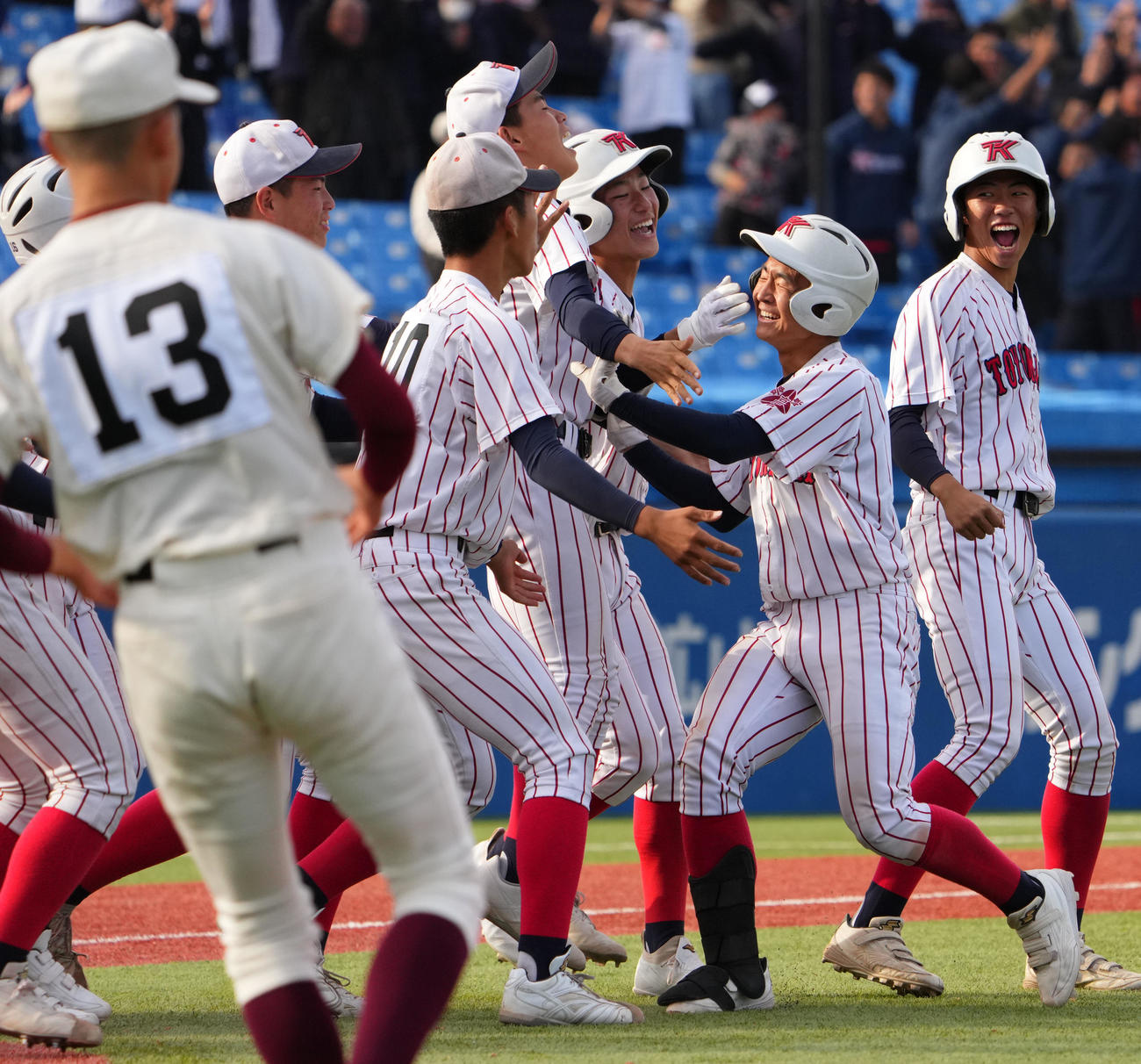 高知対豊川　11回裏タイブレーク豊川2死二、三塁、中越え2点適時打を放ちチームメートと抱き合う高橋（右から2人目）（撮影・横山健太）