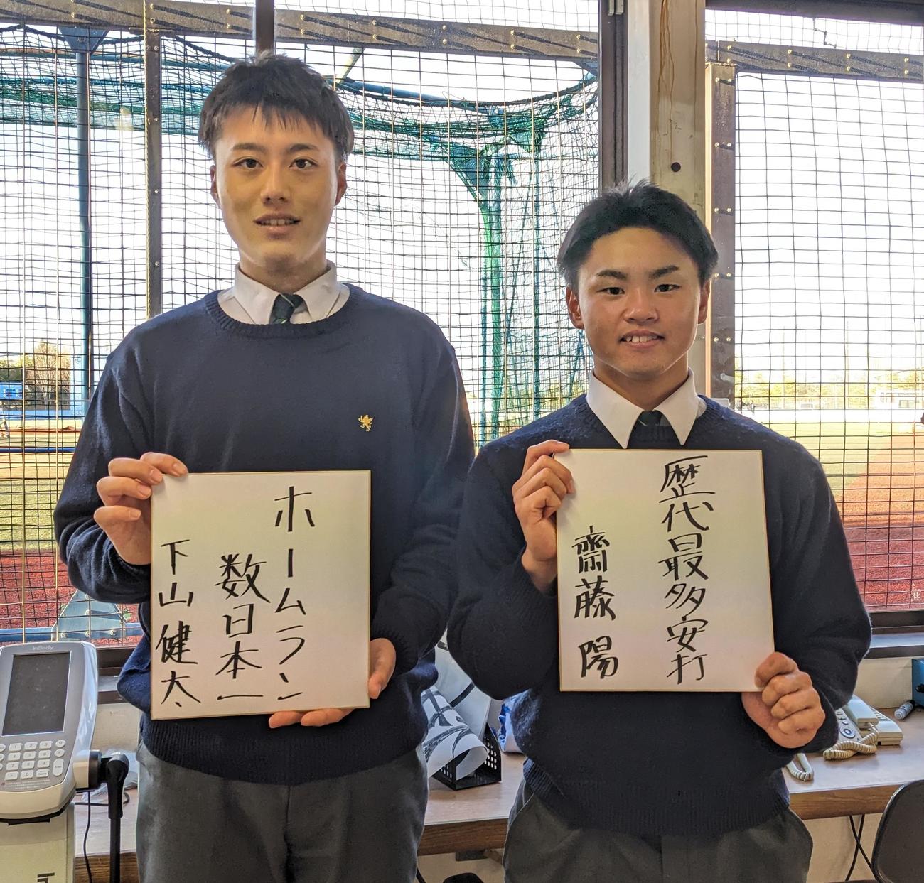 色紙に「ホームラン数日本一」と記した下山（左）と「歴代最多安打」と記した斎藤