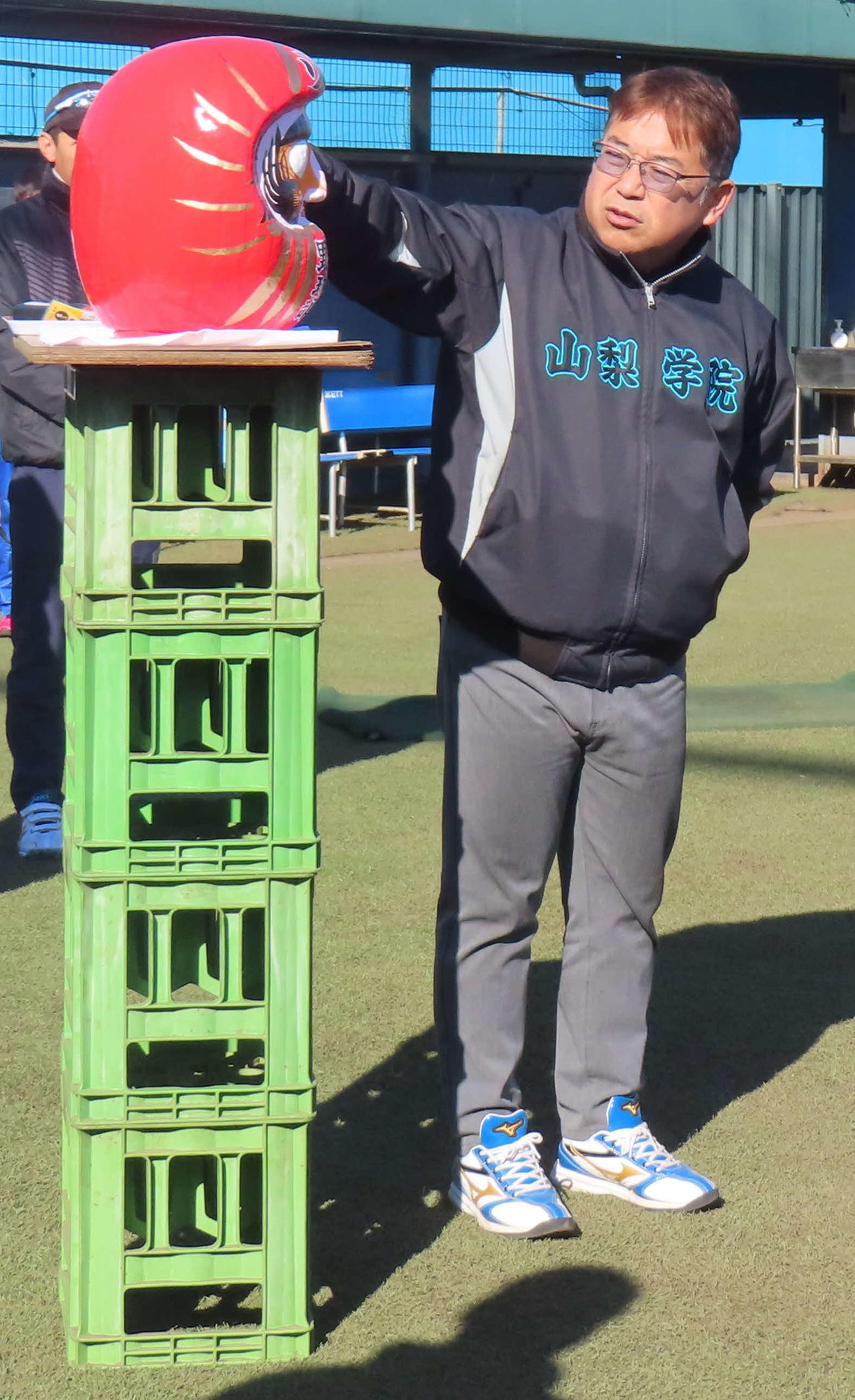 必勝ダルマを横に全体ミーティングで部員たちを激励する山梨学院・吉田監督（撮影・佐瀬百合子）