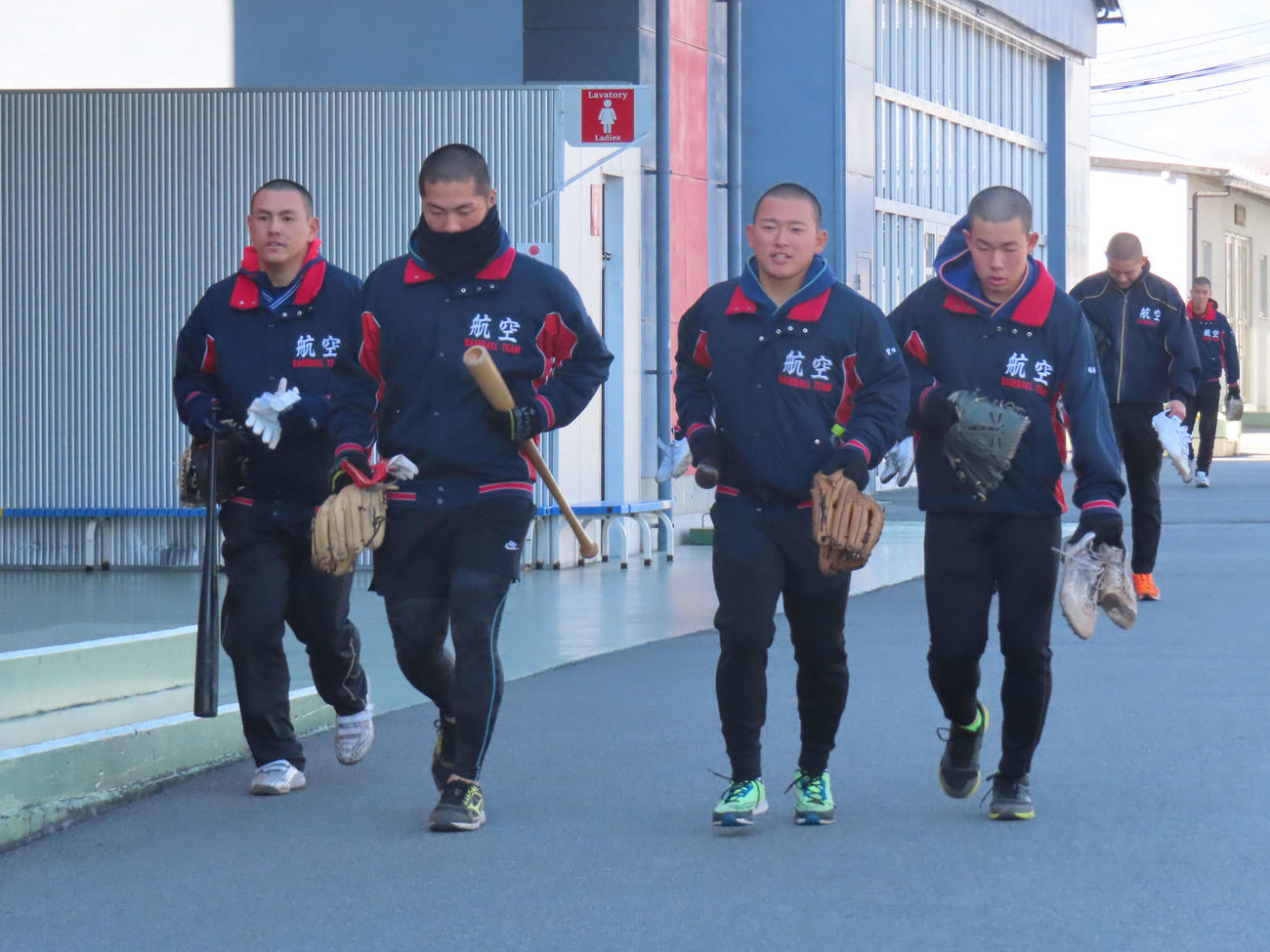 グラブやバットを持ち練習に向かう日本航空石川の野球部員たち（2024年1月16日撮影）