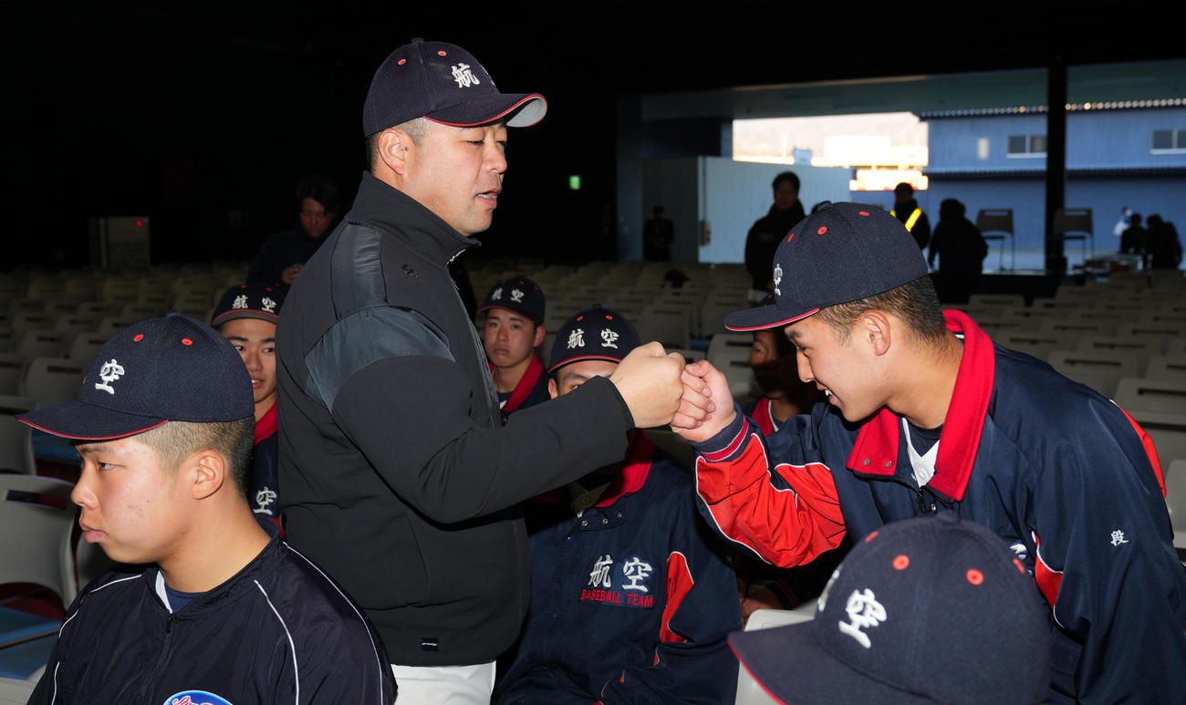 取材後、選手たちとタッチを交わす日本航空石川・中村監督（左）（撮影・横山健太）