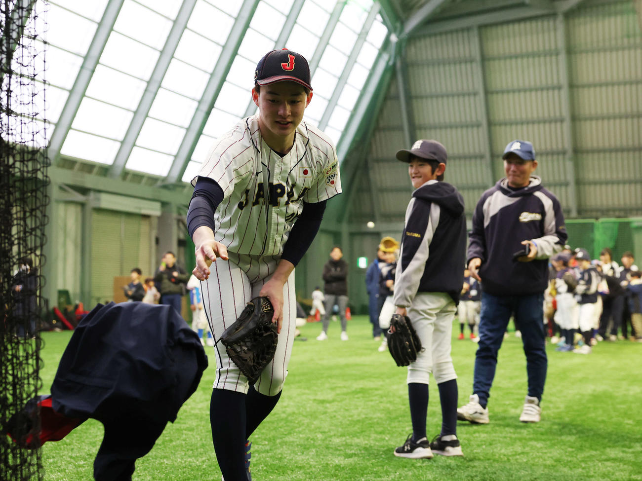 「野球で遊ぼう2024」で子どもたちとの記念撮影のため、上着を脱ぎ侍ジャパンU18のユニホーム姿になる慶応・丸田（撮影・宮地輝）