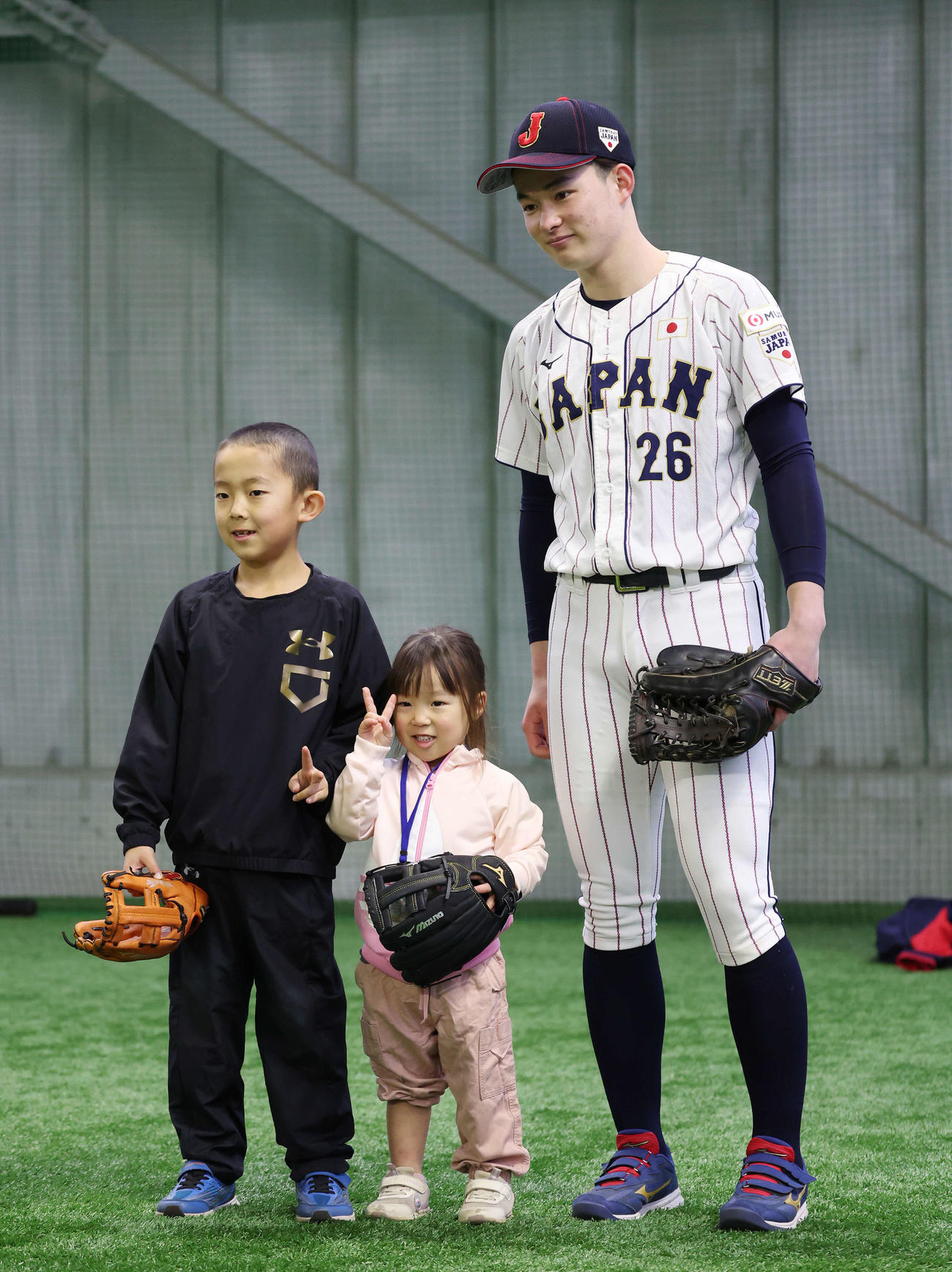 「野球で遊ぼう2024」で侍ジャパンU18のユニホーム姿で子どもたちと笑顔で記念撮影する慶応・丸田（撮影・宮地輝）