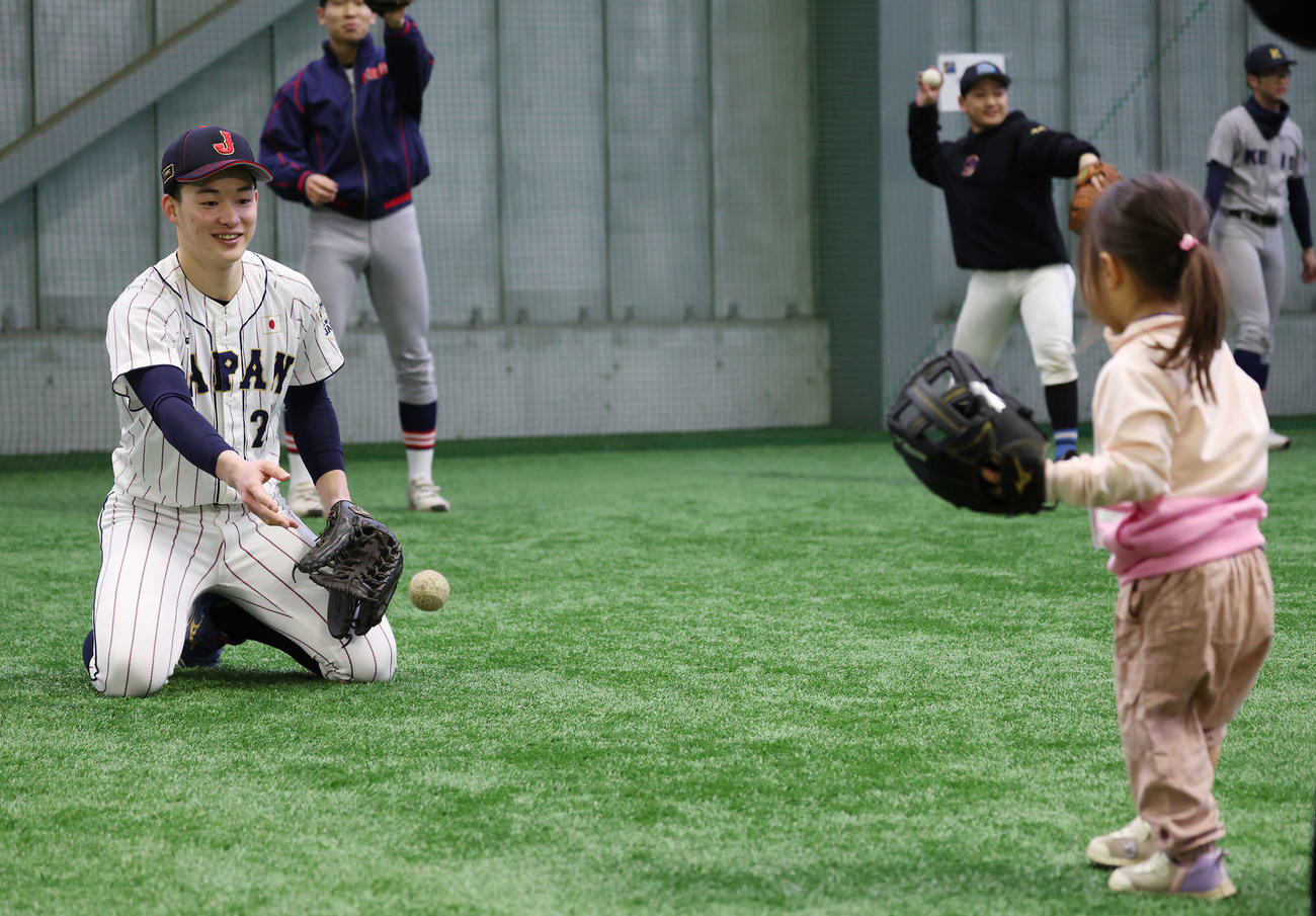 「野球で遊ぼう2024」で侍ジャパンU18のユニホームを着て、子どもたちと笑顔でキャッチボールをする慶応・丸田（撮影・宮地輝）