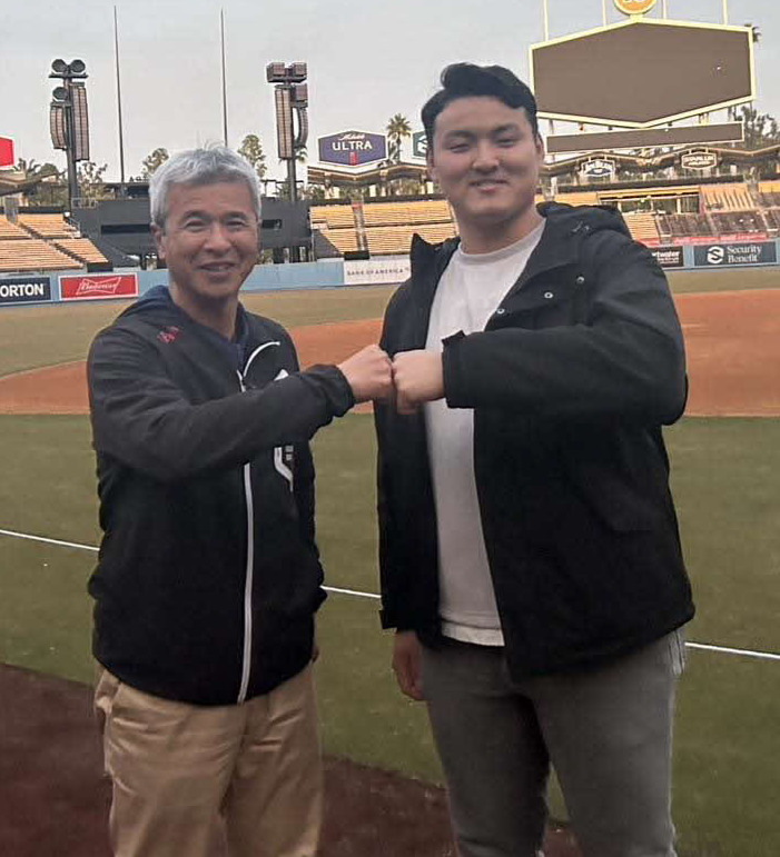 アメリカの大学、公式訪問中に、ドジャースタジアムを訪れ、グータッチを交わす、通訳兼アドバイザーの友永順平さん（左）と花巻東・佐々木麟（友永氏提供）