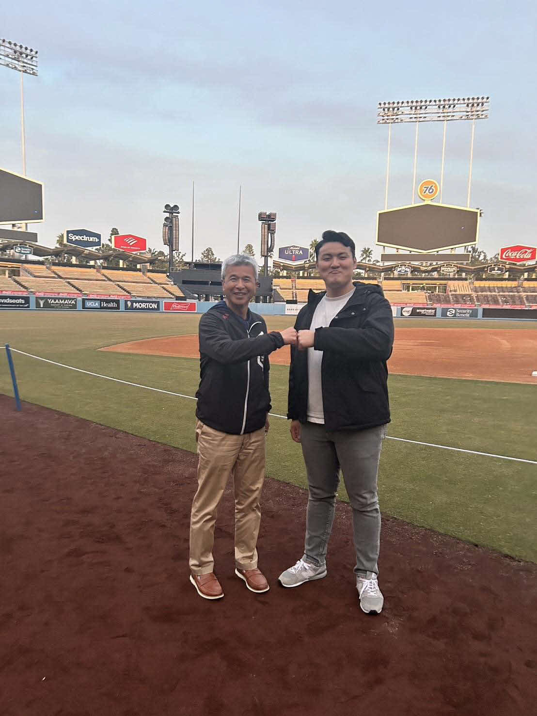 アメリカの大学、公式訪問中に、ドジャースタジアムを訪れ、グータッチを交わす、通訳兼アドバイザーの友永順平さん（左）と花巻東・佐々木麟（友永氏提供）