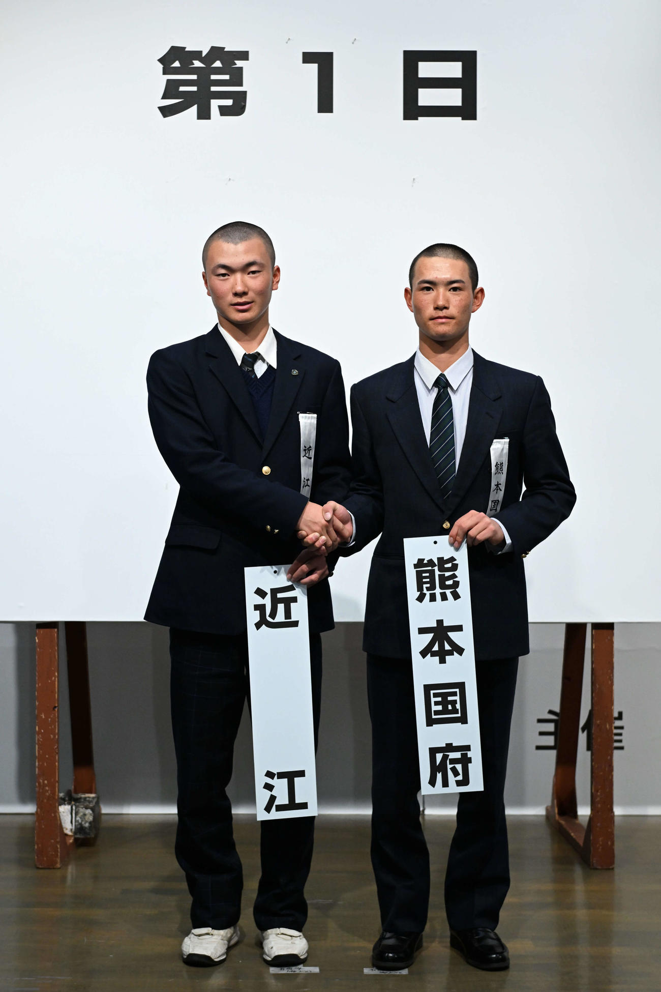対戦が決まり握手を交わす近江の大石主将（左）と熊本国府の野田主将（代表撮影）
