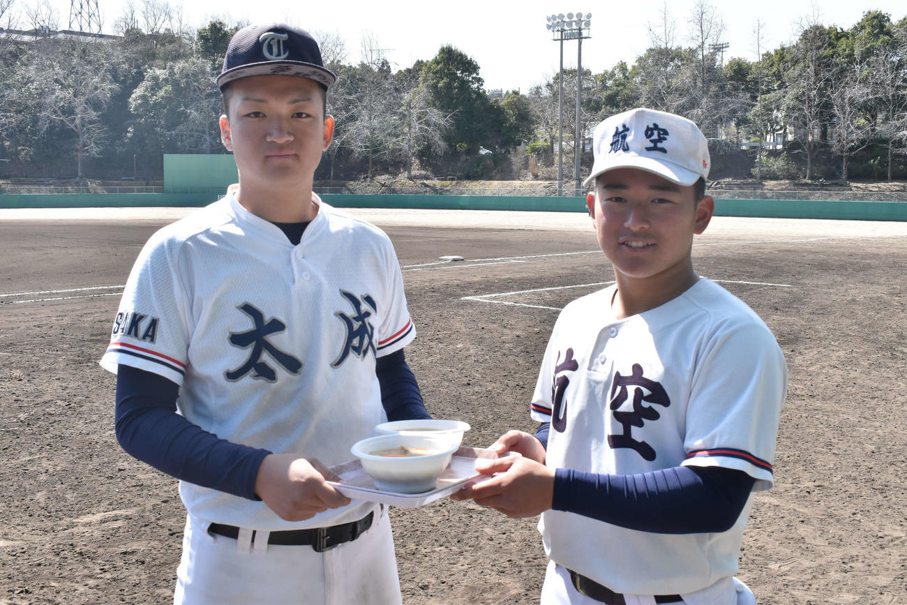 太成学院大高・有水主将（左）から炊き出しの豚汁を受け取る日本航空石川・宝田主将（撮影・古財稜明）