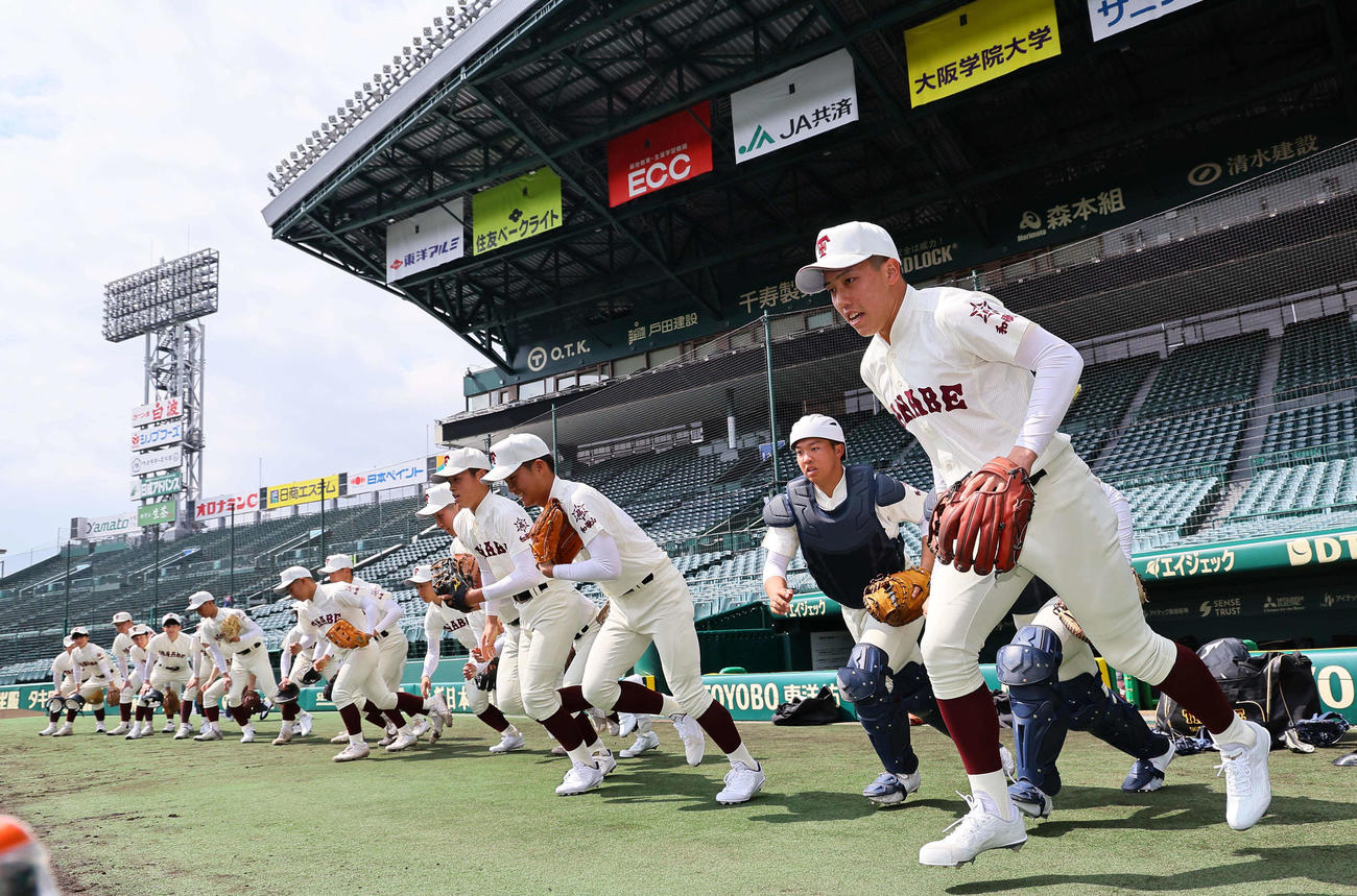 甲子園球場のグラウンドに元気よく飛び出す田辺ナイン（撮影・上田博志）