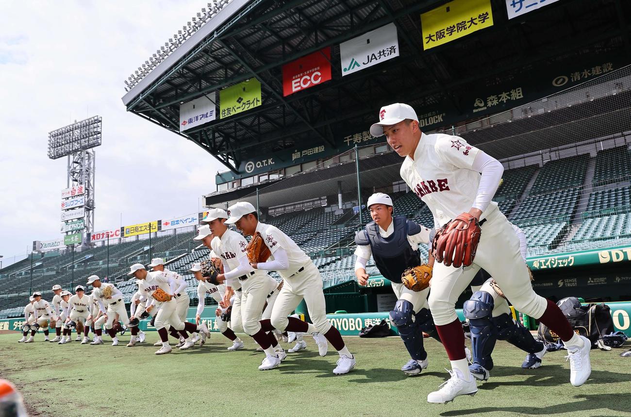 甲子園球場のグラウンドに元気よく飛び出す田辺ナイン（撮影・上田博志）