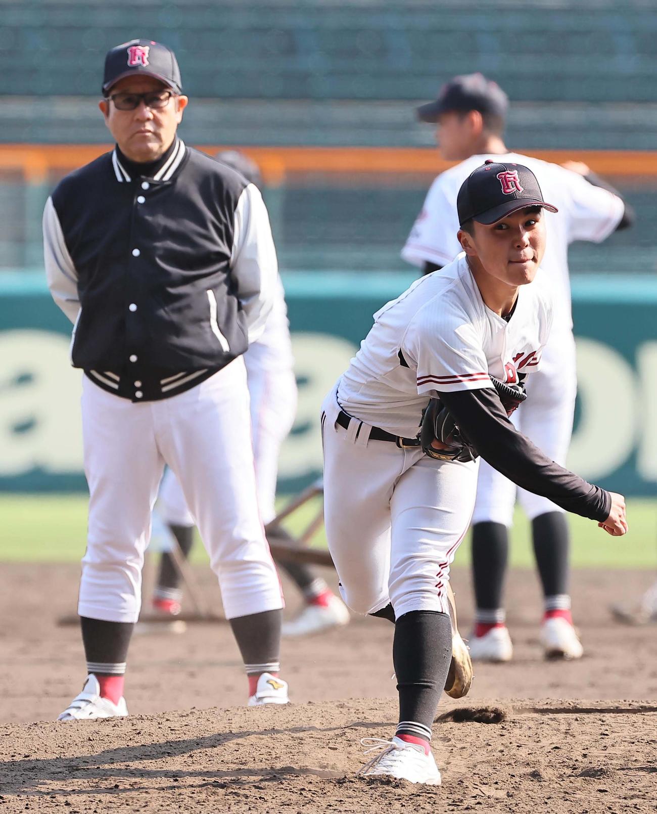 広陵・中井監督（左）のチェックを受けながら投球練習をするエース高尾（撮影・上田博志）