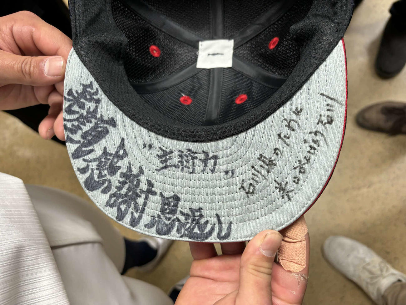 太字で「笑顔　感謝　恩返し」、右側には「石川県のために　共にがんばろう石川」と書かれた日本航空石川・宝田主将の帽子（撮影・古財稜明）
