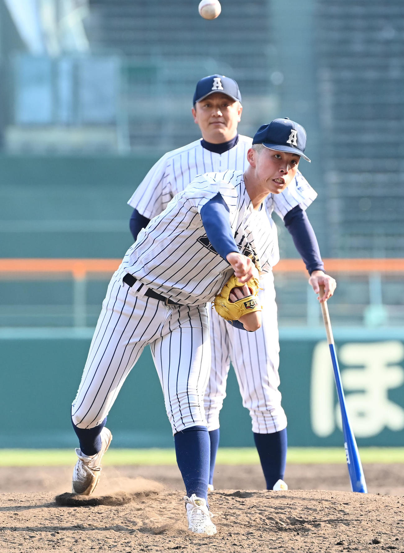 阿南光・高橋徳監督（後方）が見守る中、投球練習をする阿南光・吉岡暖（撮影・石井愛子）
