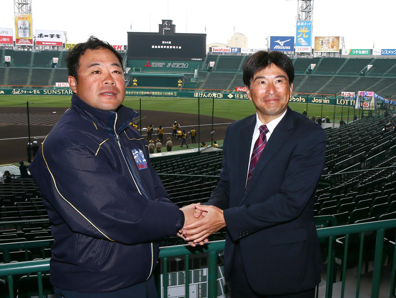 甲子園球場で握手をかわす日本航空石川の中村監督（左）と常総学院の島田監督（撮影・上山淳一）