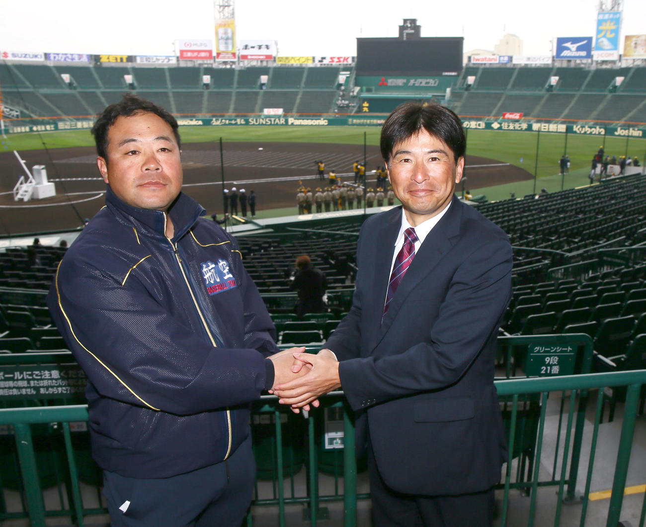 甲子園球場で握手をかわす日本航空石川の中村監督（左）と常総学院の島田監督（撮影・上山淳一）
