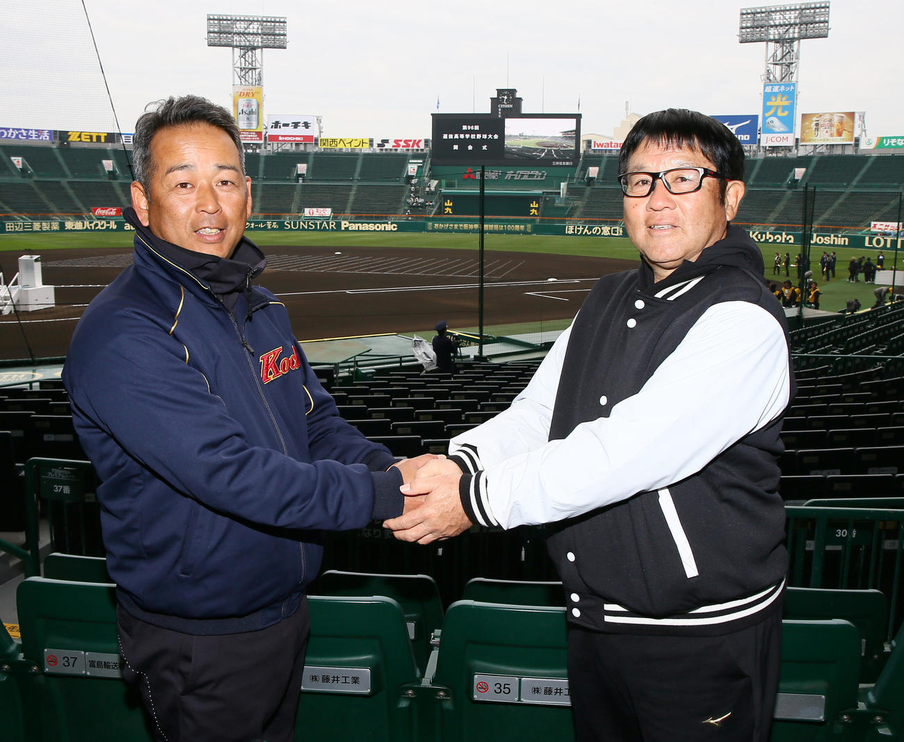 甲子園球場で握手をかわす高知の浜口監督（左）と広陵の中井監督（撮影・上山淳一）