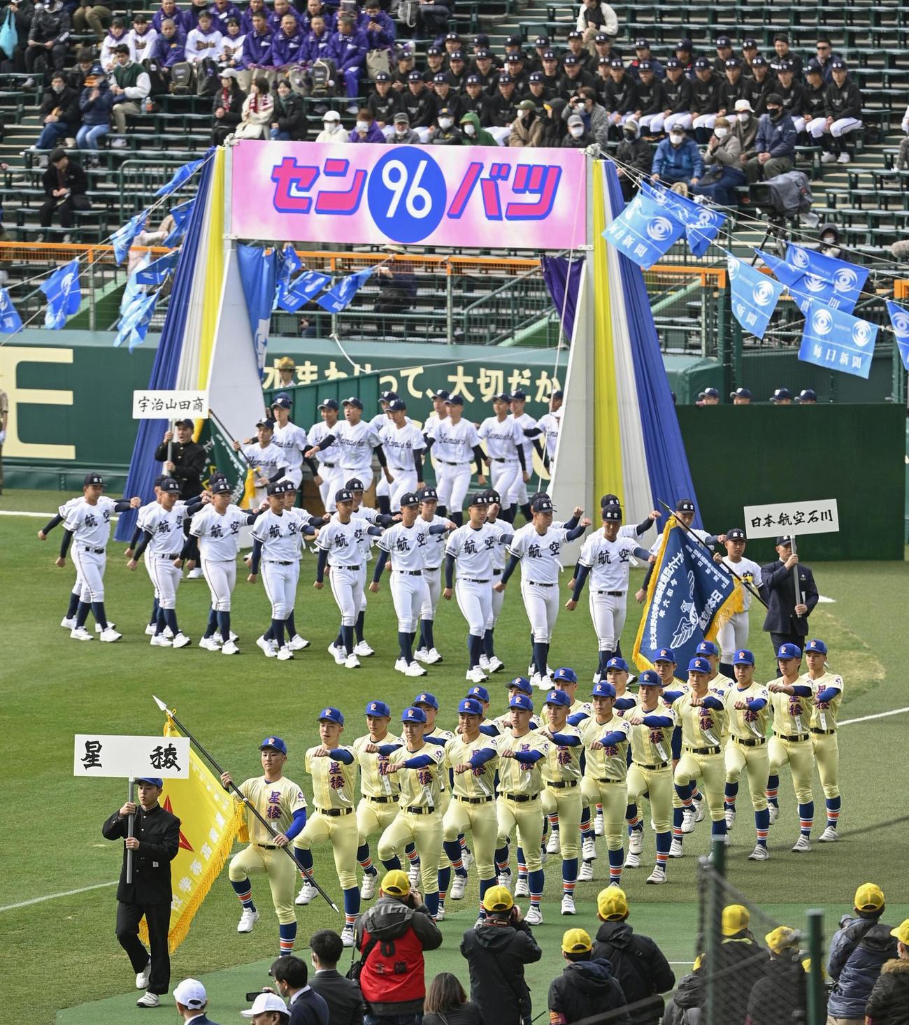 第96回選抜高校野球大会の開会式で、入場行進する星稜（手前）、日本航空石川の選手たち（共同）