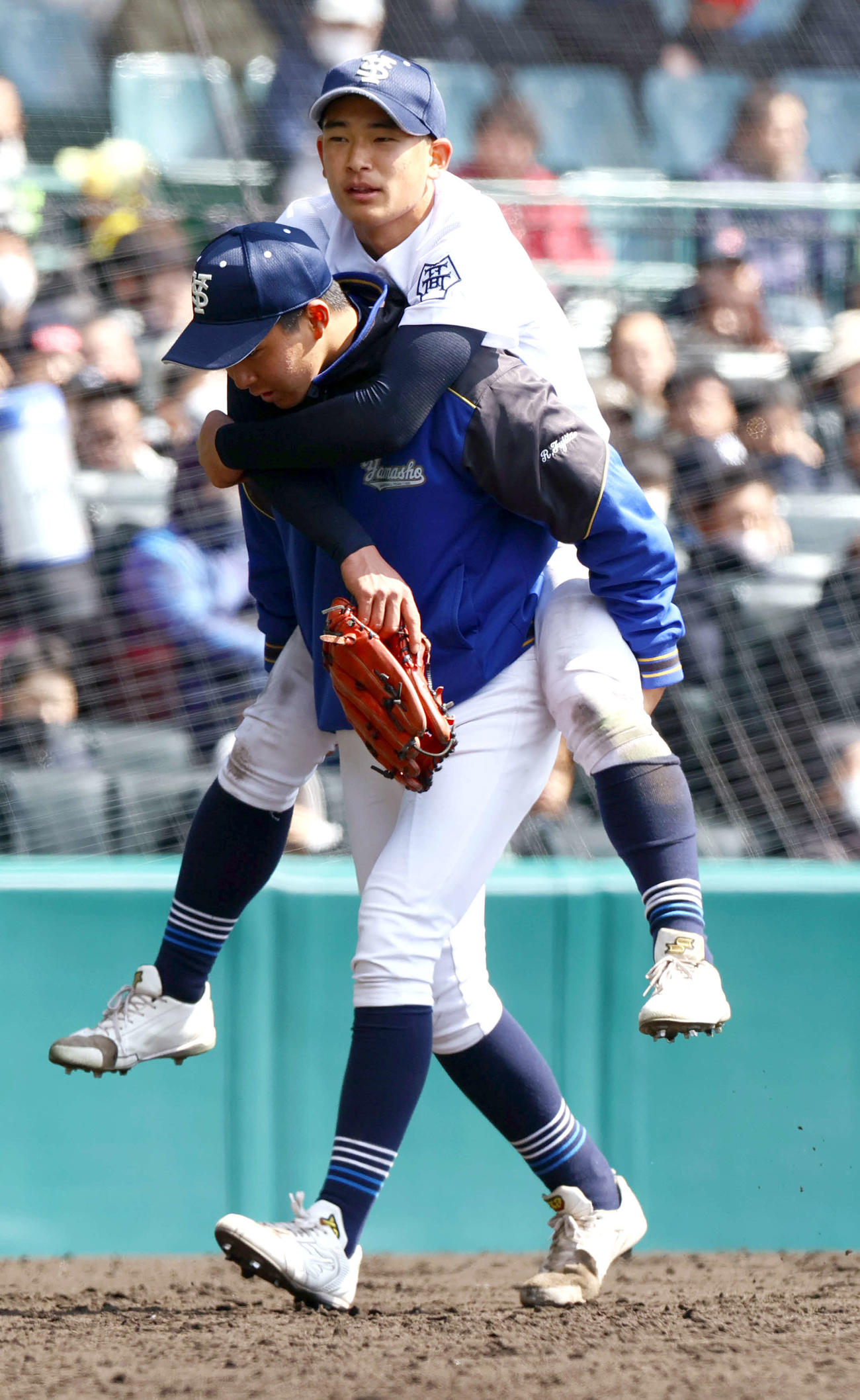 宇治山田商対東海大福岡　6回裏東海大福岡1死、佐藤の左飛を好捕した左翼手・郷（上）は負傷交代で仲間に運ばれる（撮影・上山淳一）