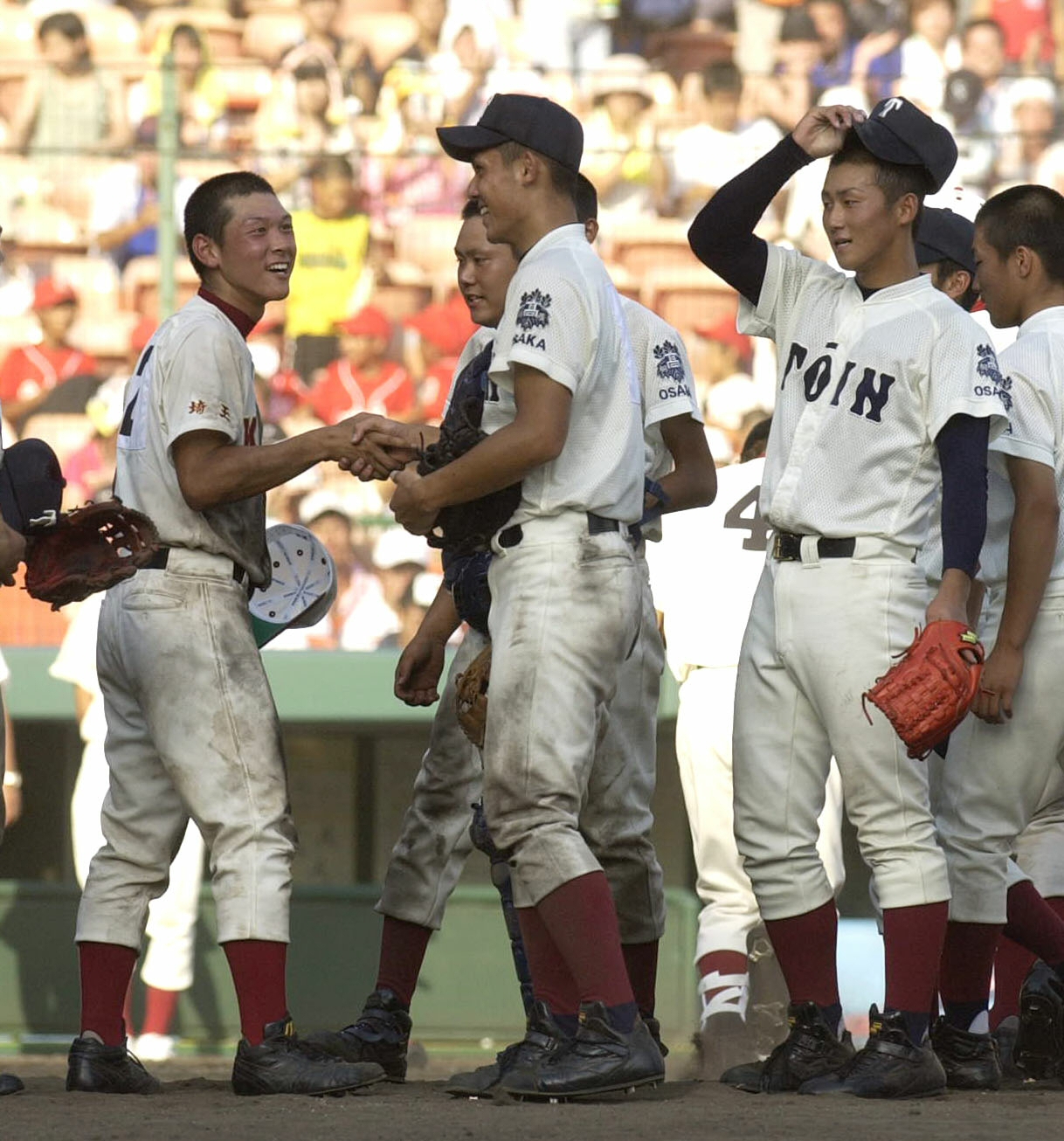 2005年8月、健闘をたたえあう春日部共栄鶴岡賢二郎主将（左）と大阪桐蔭辻内崇伸（中央）。右は中田翔