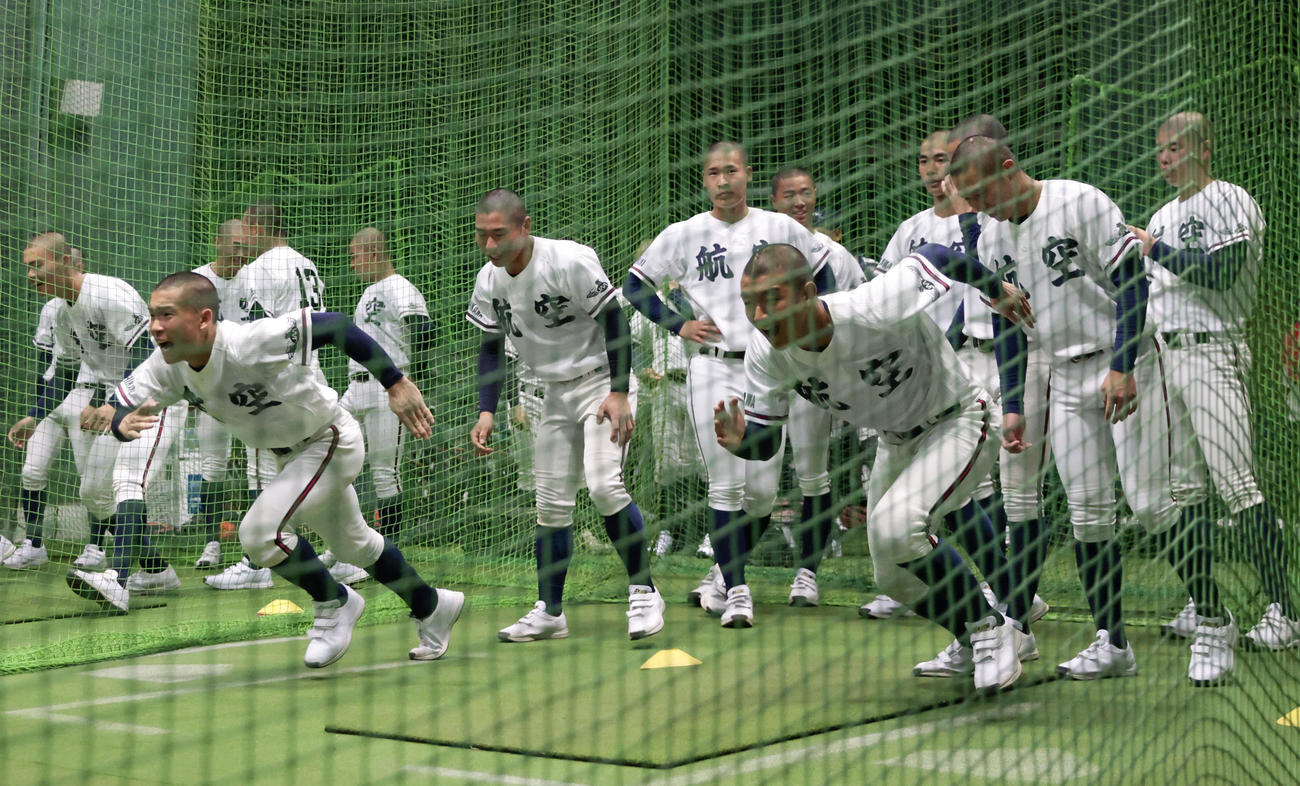 天候不良で試合が順延となり、室内練習場で調整する日本航空石川の選手たち（共同）