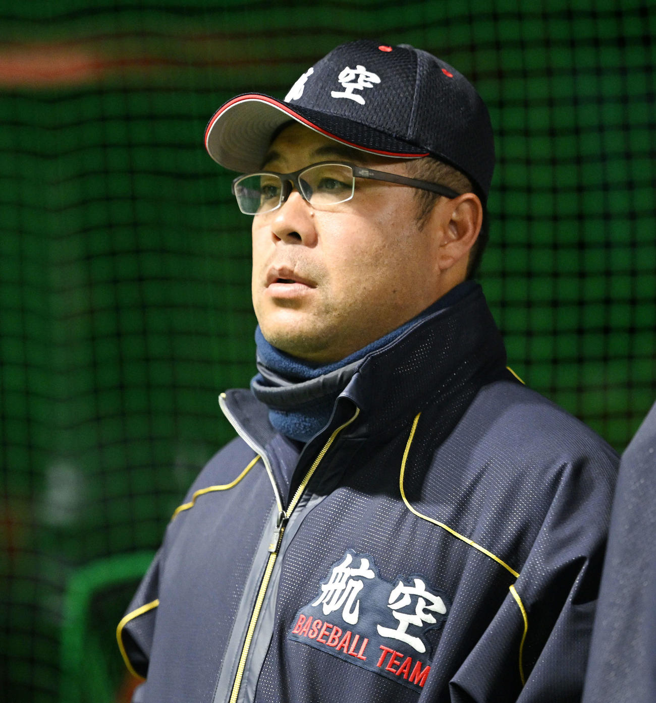 室内練習場で調整する選手を見守る日本航空石川・中村監督（撮影・滝沢徹郎）