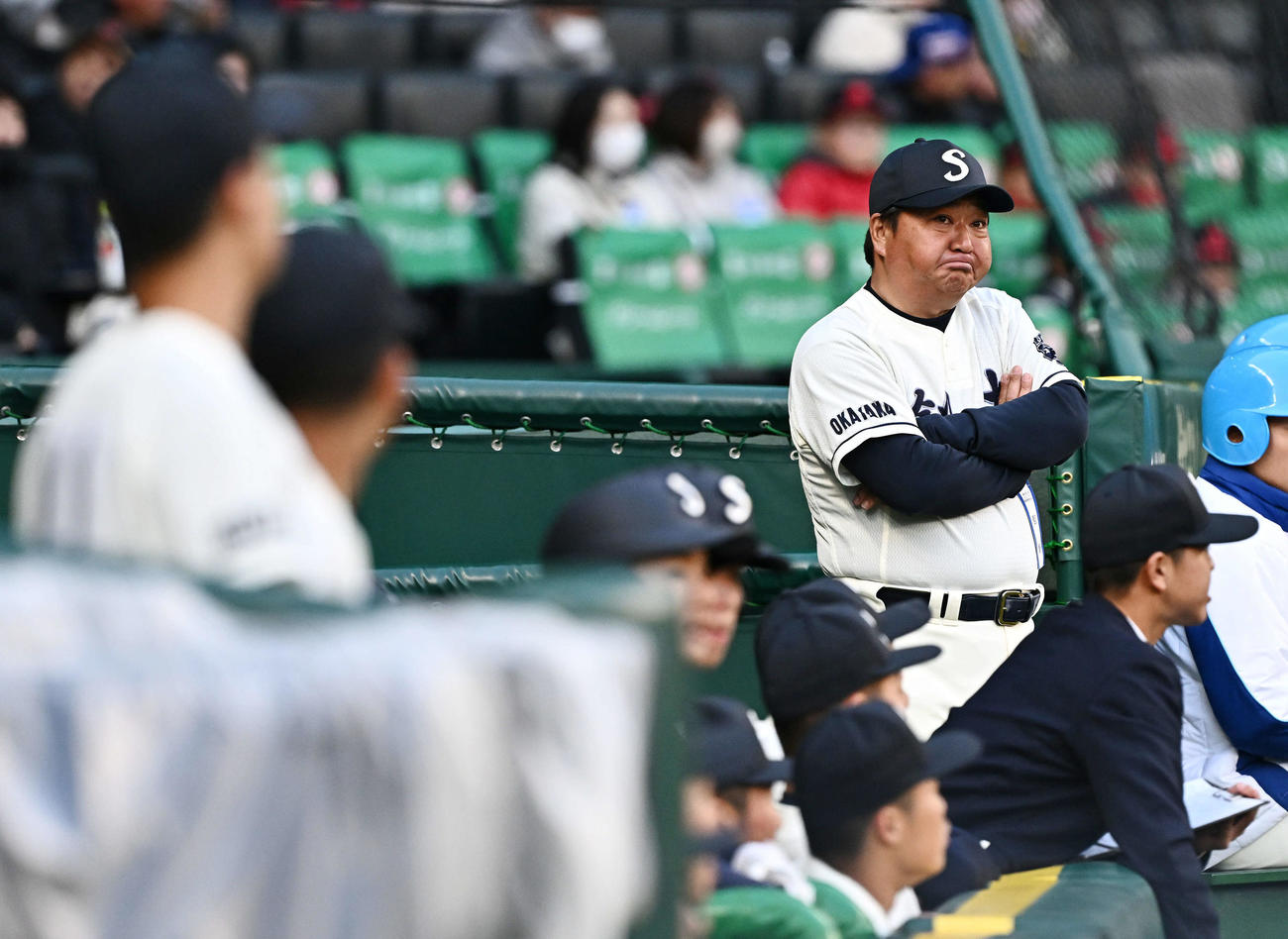 創志学園対山梨学院　9回表、戦況を見守る創志学園・門馬監督（右後方）（撮影・滝沢徹郎）