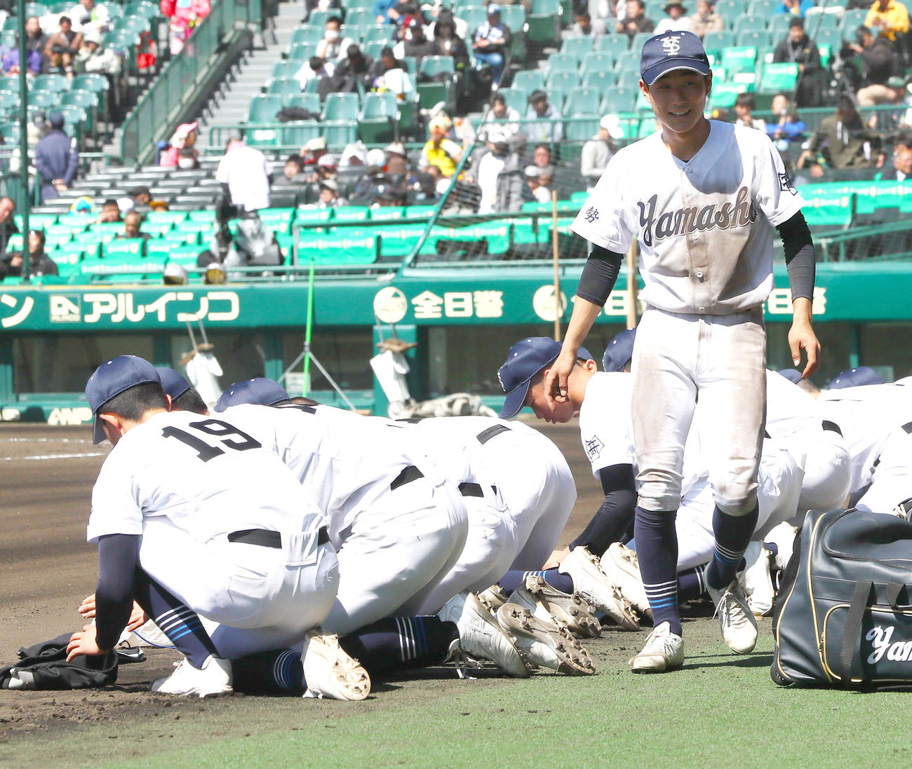 中央学院対宇治山田商　中央学院に敗れ、甲子園球場の土を拾う宇治山田商の選手たち（撮影・上山淳一）