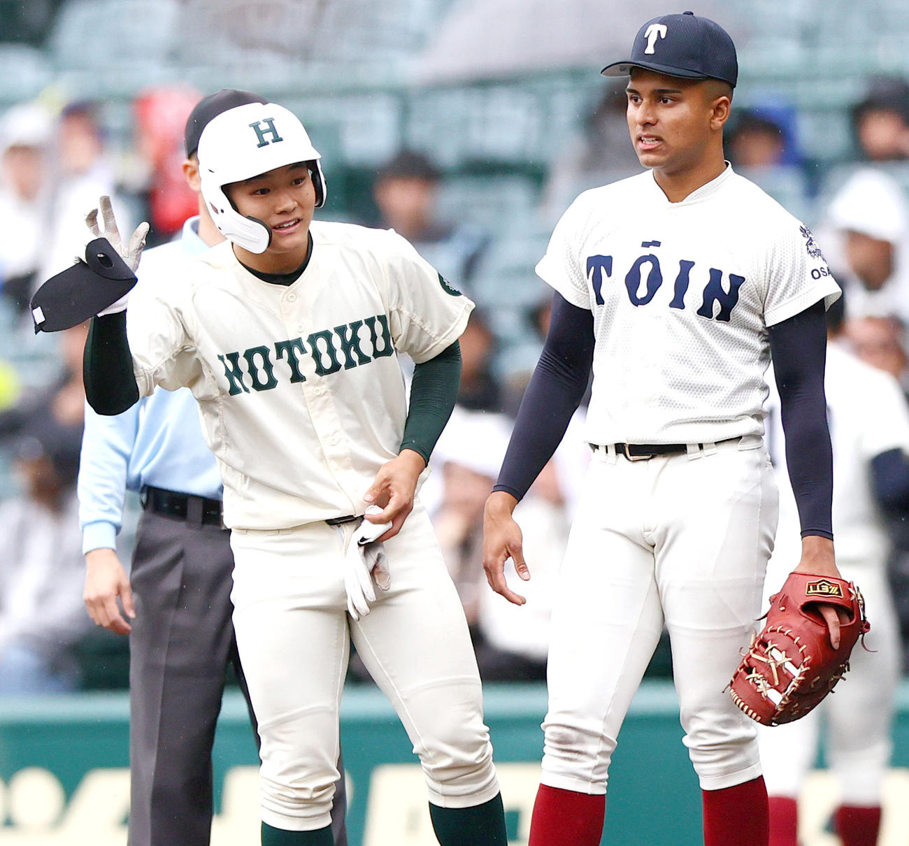 大阪桐蔭対報徳学園　1回裏報徳学園無死満塁、斎藤は先制の左前適時打を放ち一塁で笑顔を見せる。右は一塁手・ラマル（撮影・上山淳一）