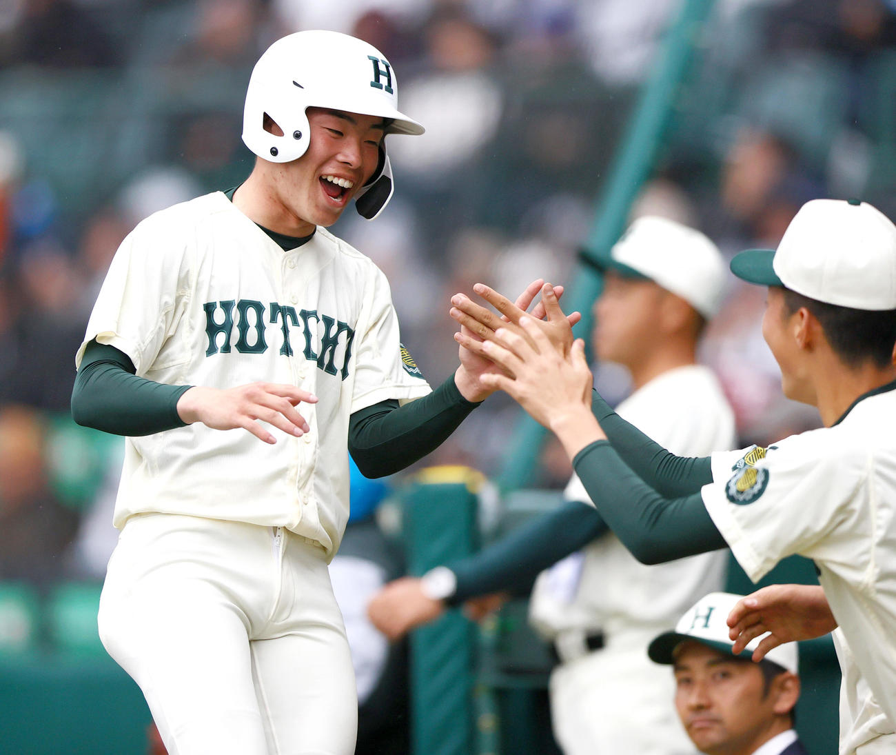 大阪桐蔭対報徳学園　1回裏報徳学園無死満塁、斎藤の左前適時打で先制生還し笑顔を見せる橋本（左）（撮影・上山淳一）