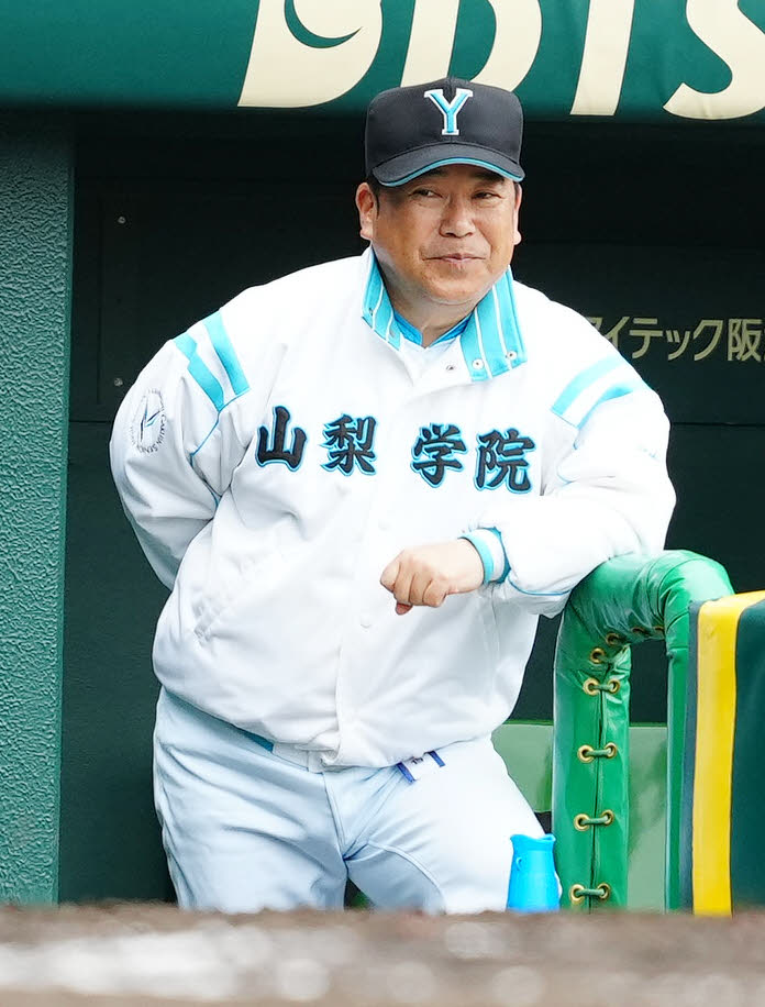 山梨学院対高崎健康福祉大高崎　4回表、ベンチから戦況を見つめる山梨学院・吉田監督（撮影・江口和貴）