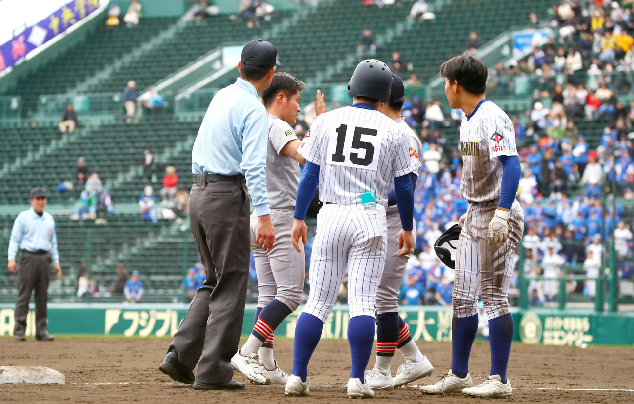 中央学院対青森山田　4回表中央学院無死一、二塁、上村のバントで進塁した二走飯山（右）と交錯した三塁手菊池伊（左から2人目）は大丈夫と合図する（撮影・上山淳一）