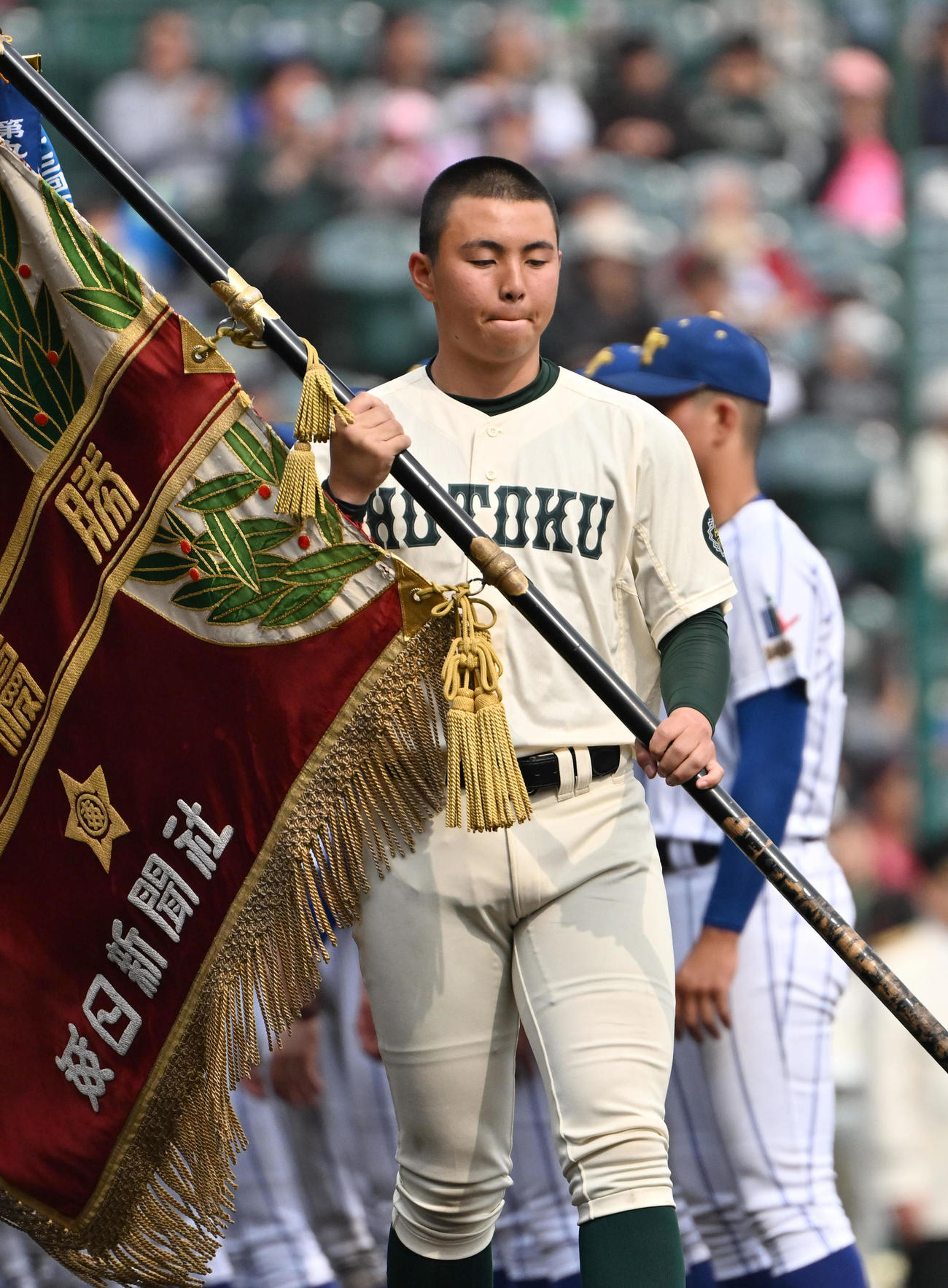 準優勝旗を手に悔しげな表情を見せる報徳学園・間木主将（撮影・石井愛子）
