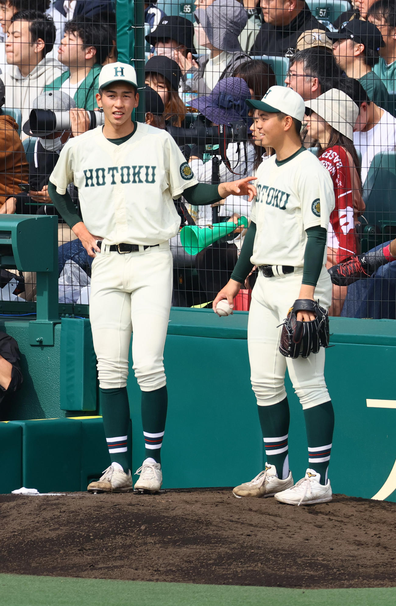報徳学園対高崎健康福祉大高崎　9回表の攻撃中、ブルペンで報徳学園・間木（右）と話す今朝丸（撮影・上山淳一）