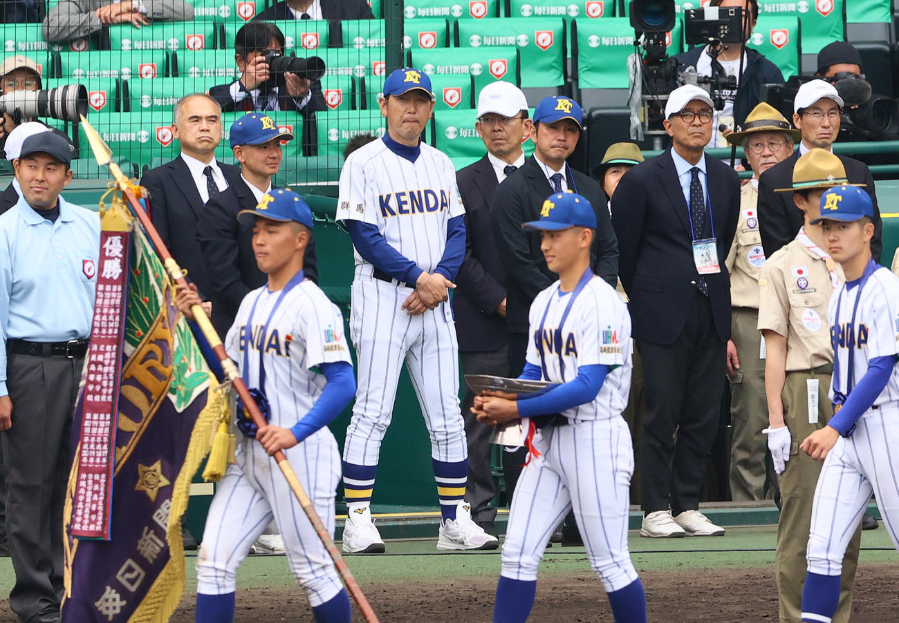 報徳学園対高崎健康福祉大高崎　場内を一周する優勝した高崎健康福祉大高崎ナインを見つめる高崎健康福祉大高崎の青柳監督（左から5人目）（撮影・上山淳一）
