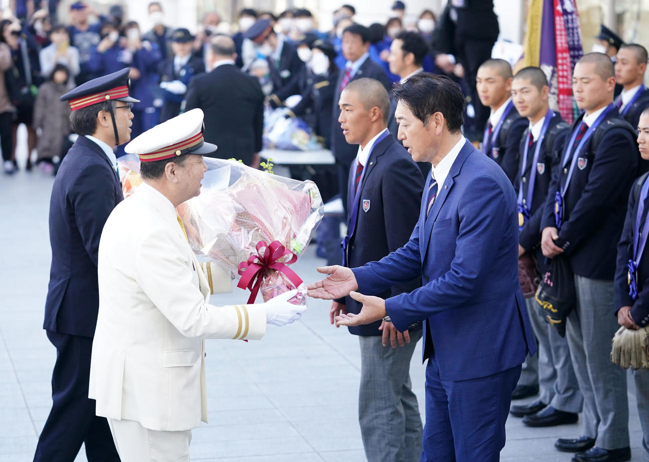 駅長から花束を受け取る高崎健康福祉大高崎・青柳監督（右）と箱山（同2人目）（撮影・横山健太）