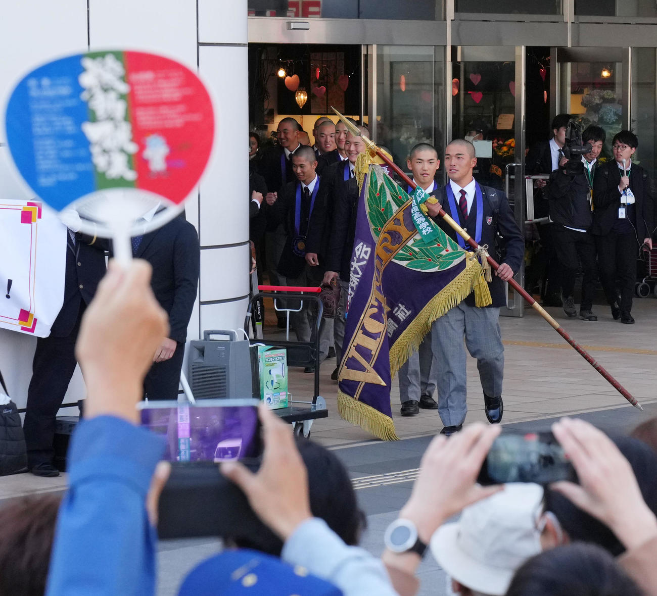 優勝旗を手に高崎駅に到着した箱山（手前）ら高崎健康福祉大高崎ナイン（撮影・横山健太）