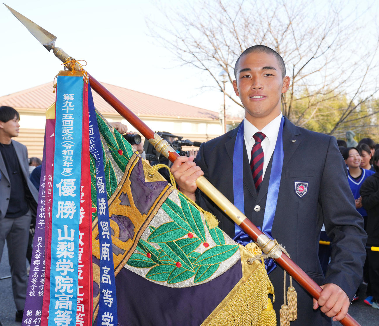 優勝旗を手に笑顔をみせる高崎健康福祉大高崎・箱山（撮影・横山健太）