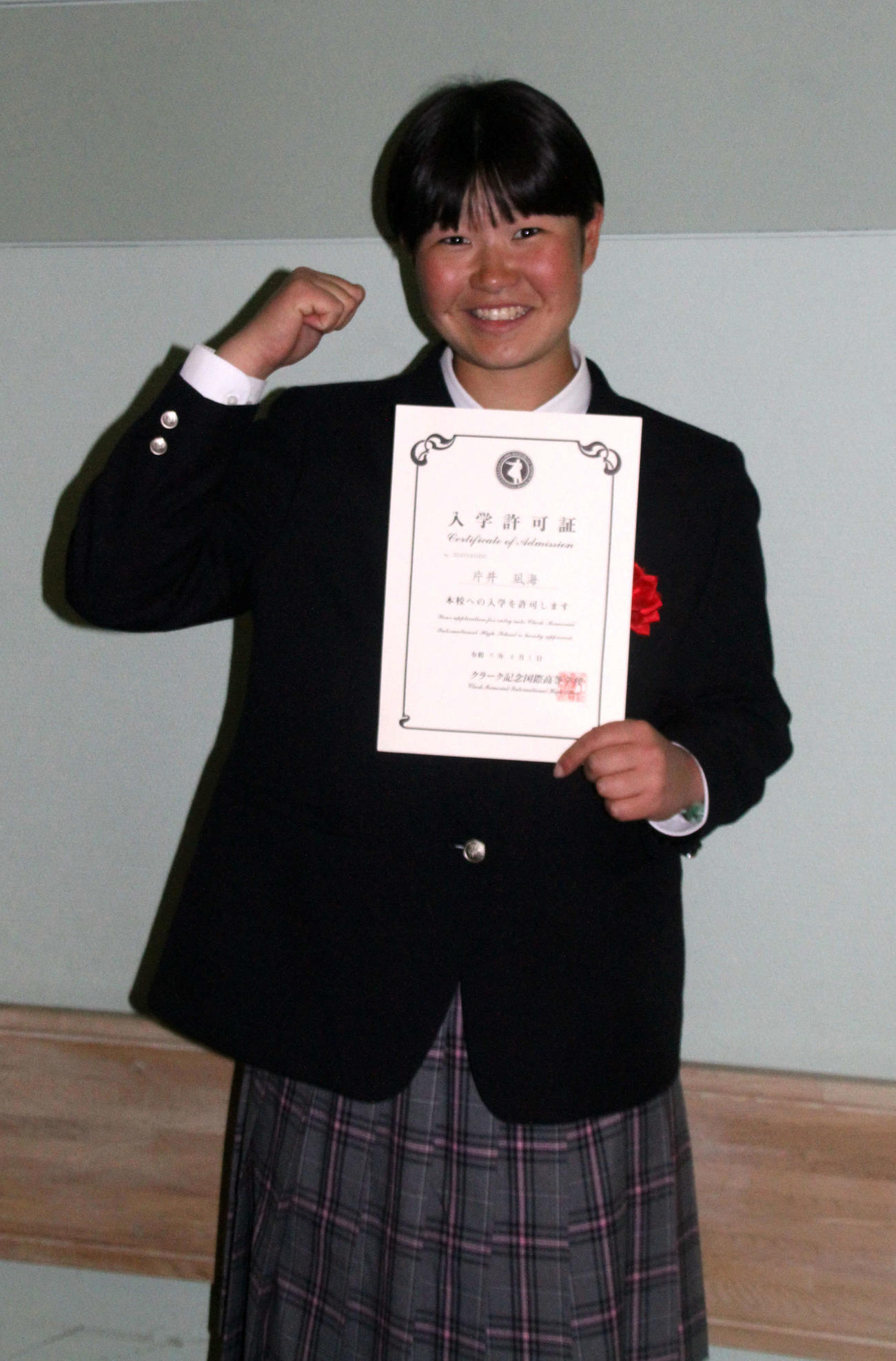 入学許可書を手に、ガッツポーズする片井（撮影・木村有優）