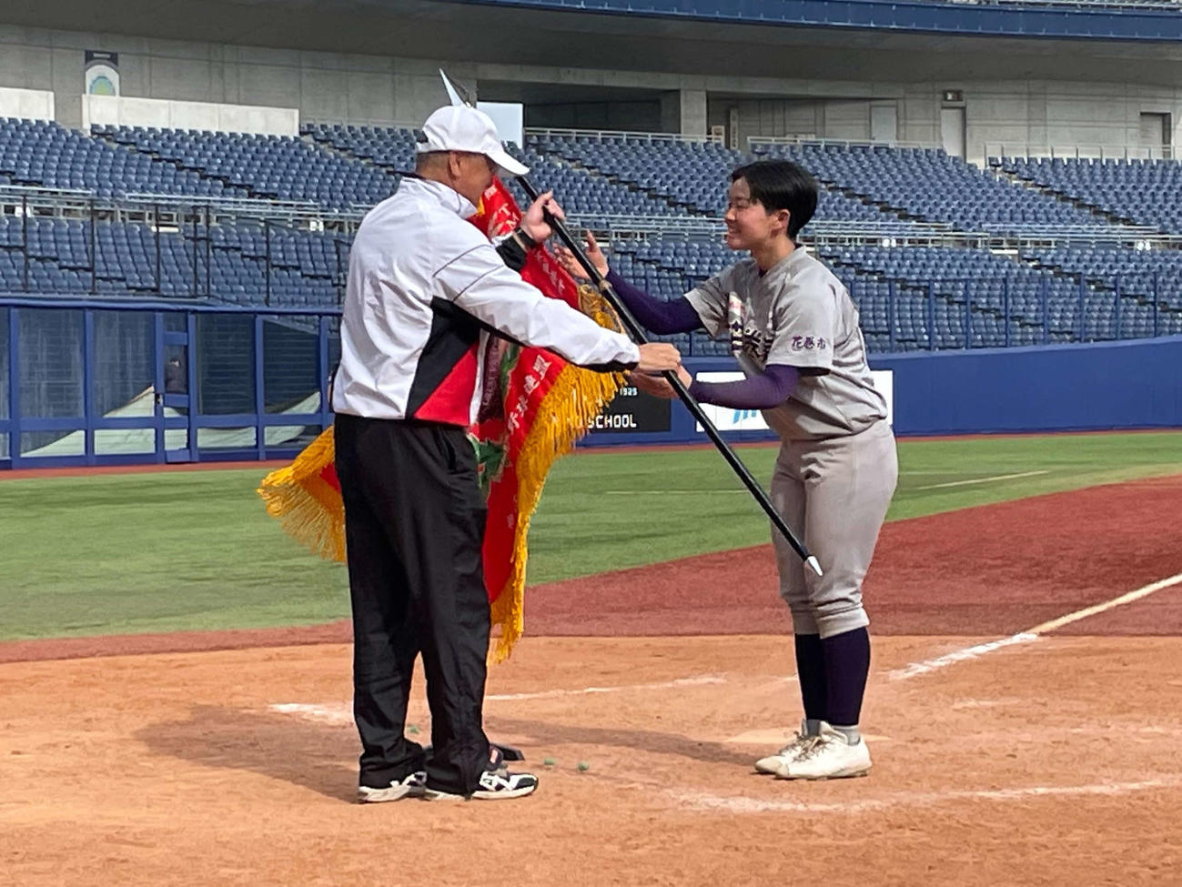 第7回女子硬式野球新潟大会で優勝旗を受け取る花巻東・平尾副主将（チーム提供）