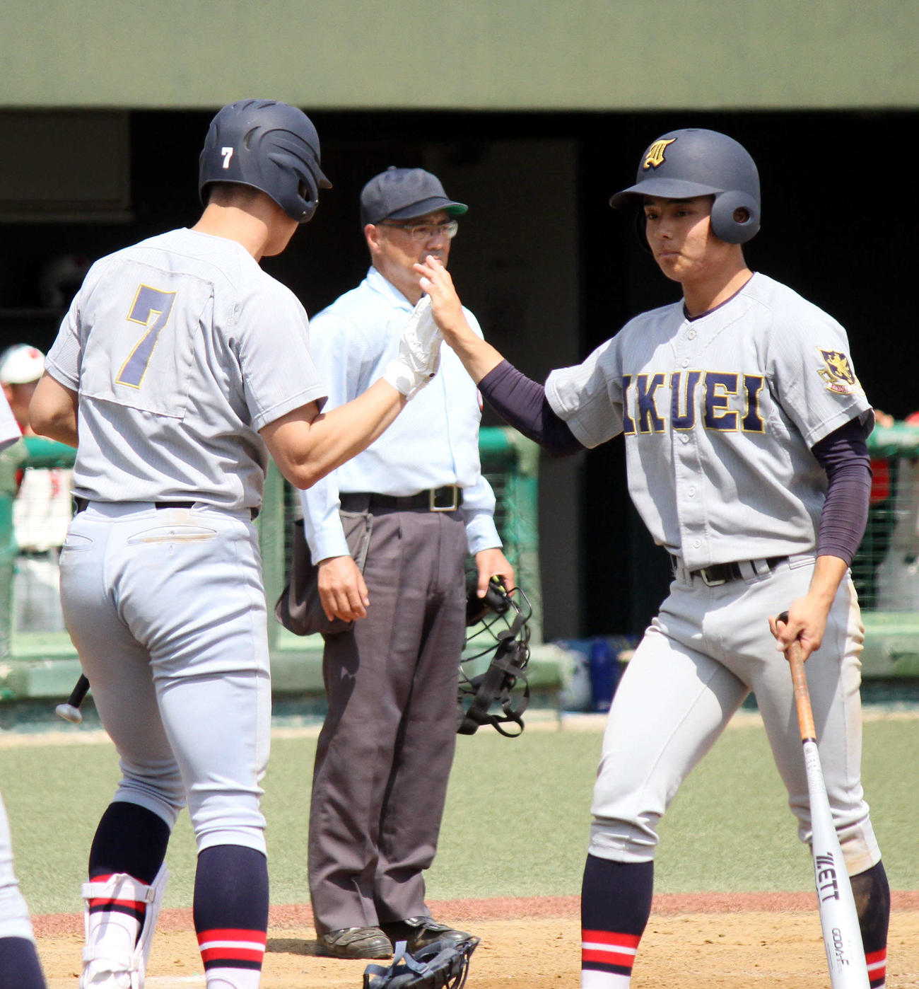 仙台育英対仙台商業　8回裏に4点目のホームを踏み、ハイタッチをかわす仙台育英・湯浅（撮影・木村有優）