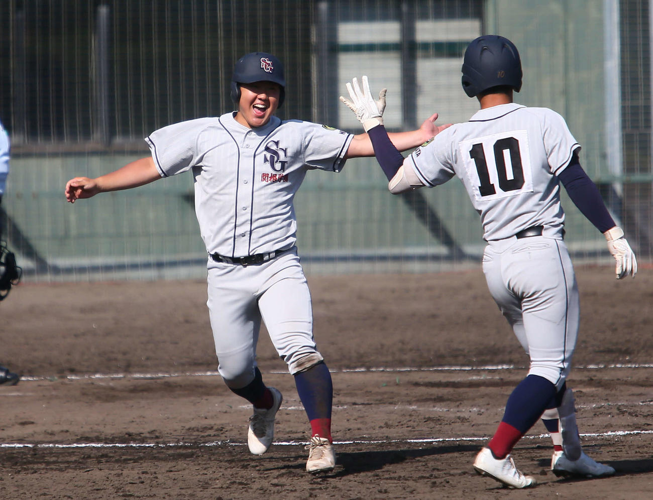 関根学園対上越　8回に同点三塁打を打った谷島（左）は勝ち越しホームも踏んで笑顔