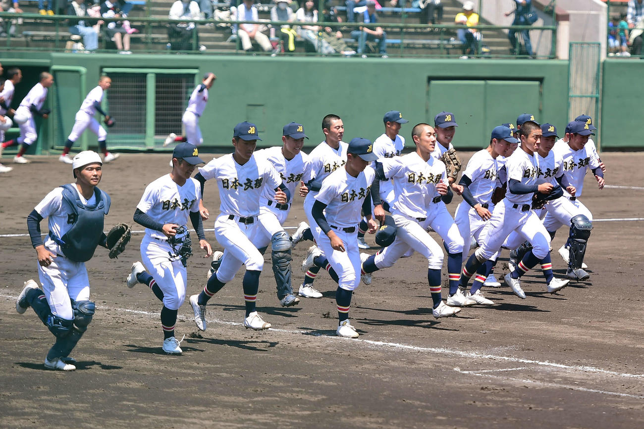 開志学園対日本文理　試合に勝利し、スタンドあいさつに向かう日本文理ナイン