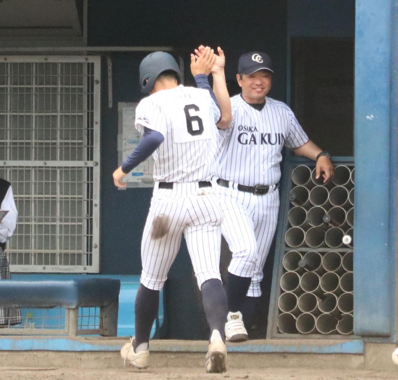 大院大高対興国　4回表、大院大高の今坂幸暉内野手（背番号6）が勝ち越しのホームを踏み辻盛英一監督とハイタッチする（撮影・林亮佑）＝2024年5月12日、大阪シティ信用金庫スタジアム