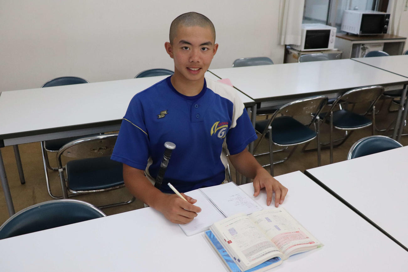 自主練習を終えた夜に寮の食堂でバットを脇に抱えながら勉強する明秀学園日立の李（撮影・保坂淑子）
